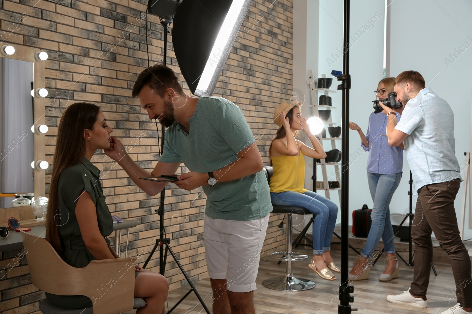 Photo of Professional team working with model in photo studio