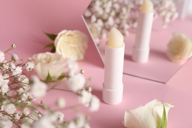 Stylish presentation of lip balm on pink background, closeup