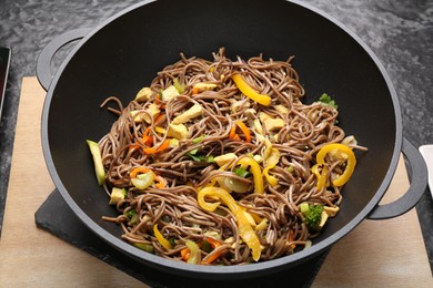 Stir-fry. Tasty noodles with vegetables and meat in wok on table