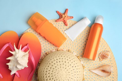 Flat lay composition with sunscreen on light blue background. Sun protection