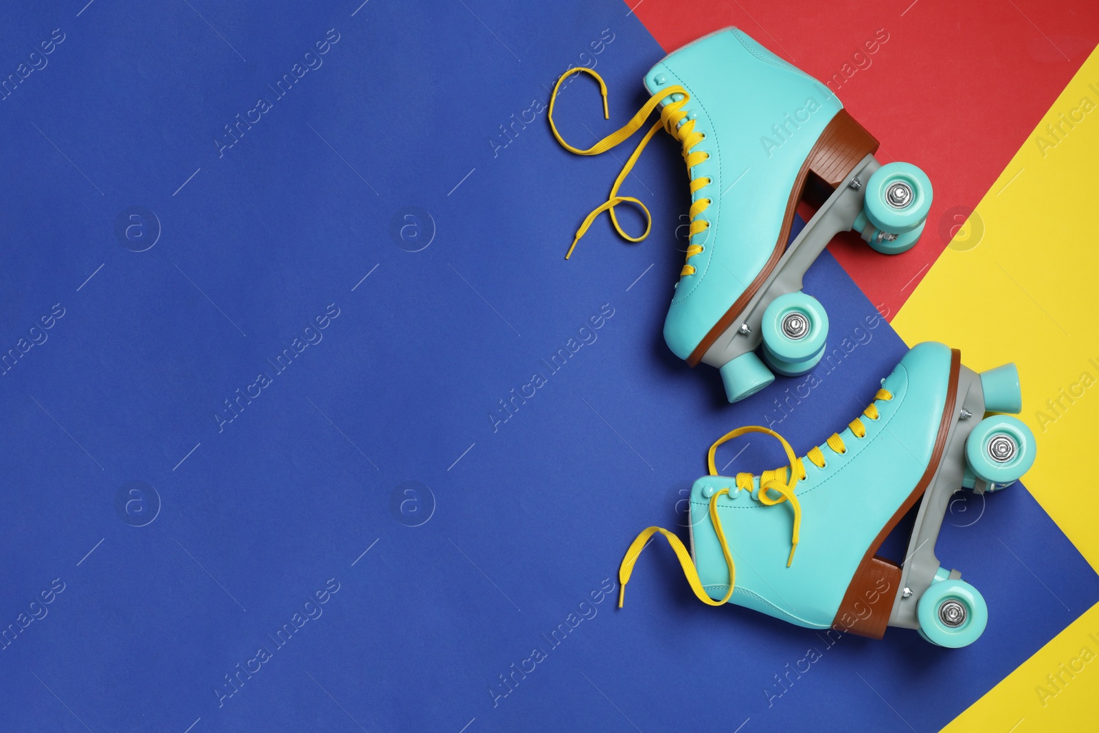 Photo of Pair of stylish quad roller skates on color background, top view with space for text