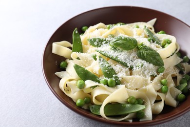 Photo of Delicious pasta with green peas and cheese on grey table, closeup