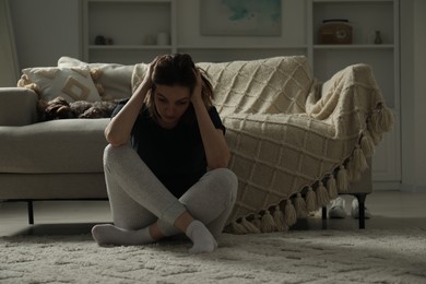 Sad young woman and her dog at home