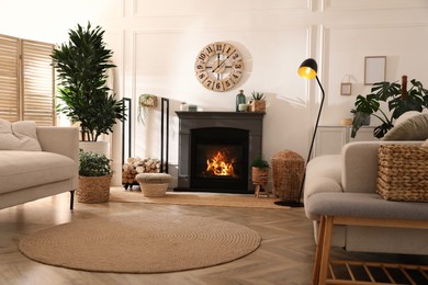 Photo of Stylish living room interior with electric fireplace, comfortable sofas and beautiful decor elements