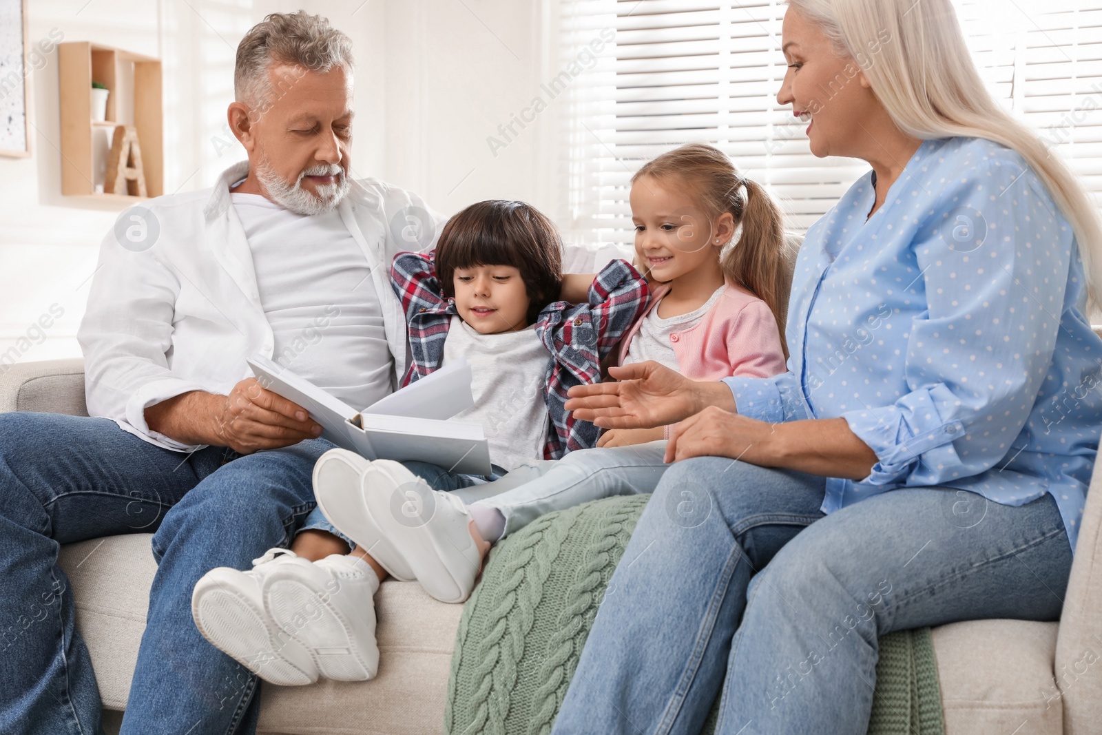 Photo of Happy grandparents spending time with grandchildren at home