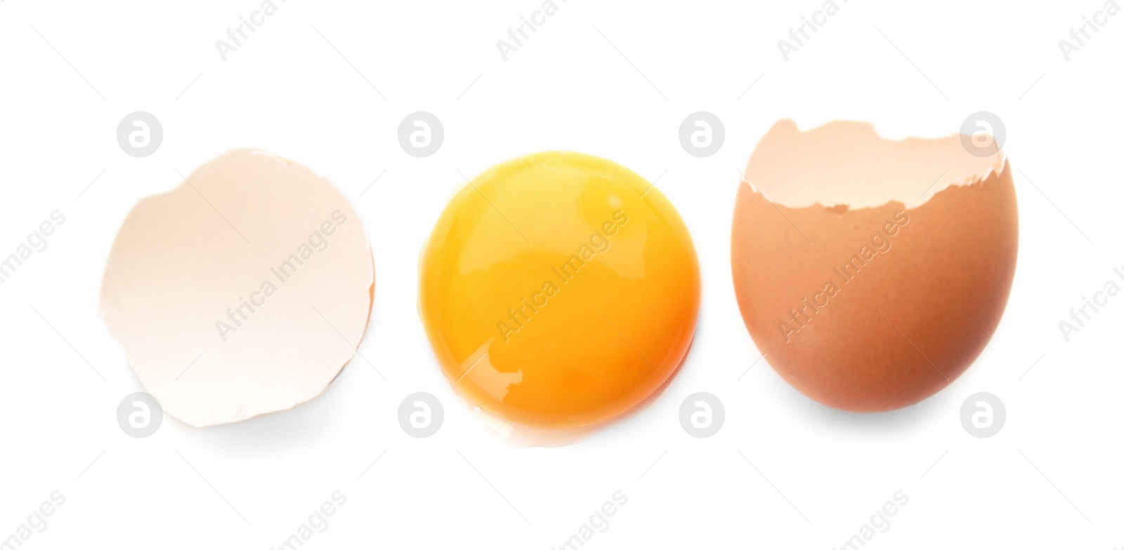 Photo of Egg yolk with cracked shell on white background, top view