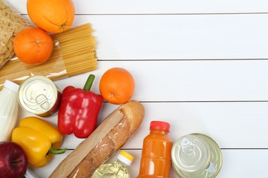 Humanitarian aid. Different food products for donation on white wooden table, flat lay. Space for text