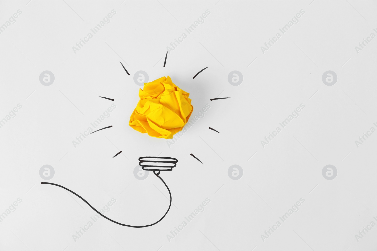 Photo of Composition with crumpled paper ball, drawing of lamp bulb and space for text on white background, top view. Creative concept