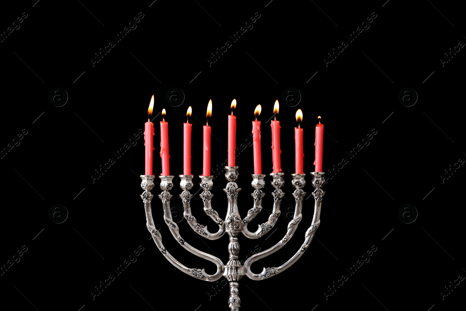 Photo of Silver menorah with burning candles against black background. Hanukkah celebration