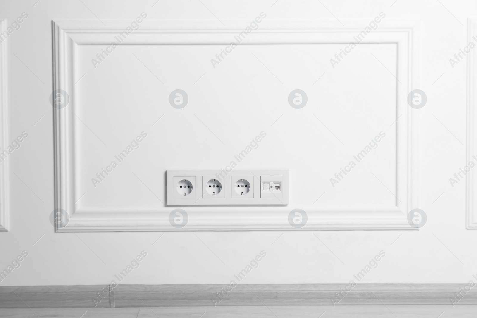 Photo of Electric power sockets on white wall, space for text