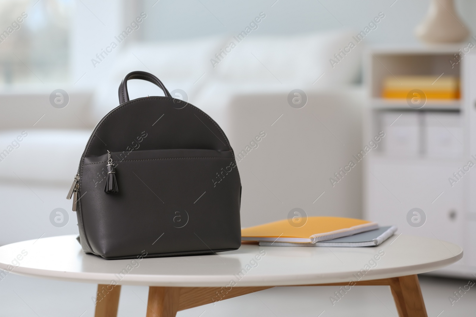 Photo of Stylish black backpack and notebooks on white table indoors, space for text