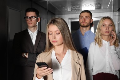 Photo of Group of office workers in modern elevator