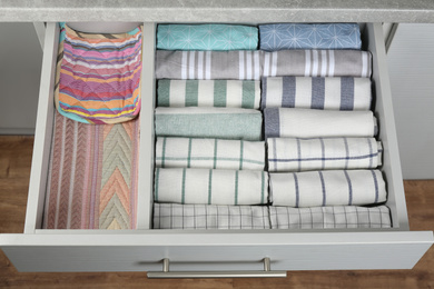 Photo of Open drawer with folded towels. Order in kitchen