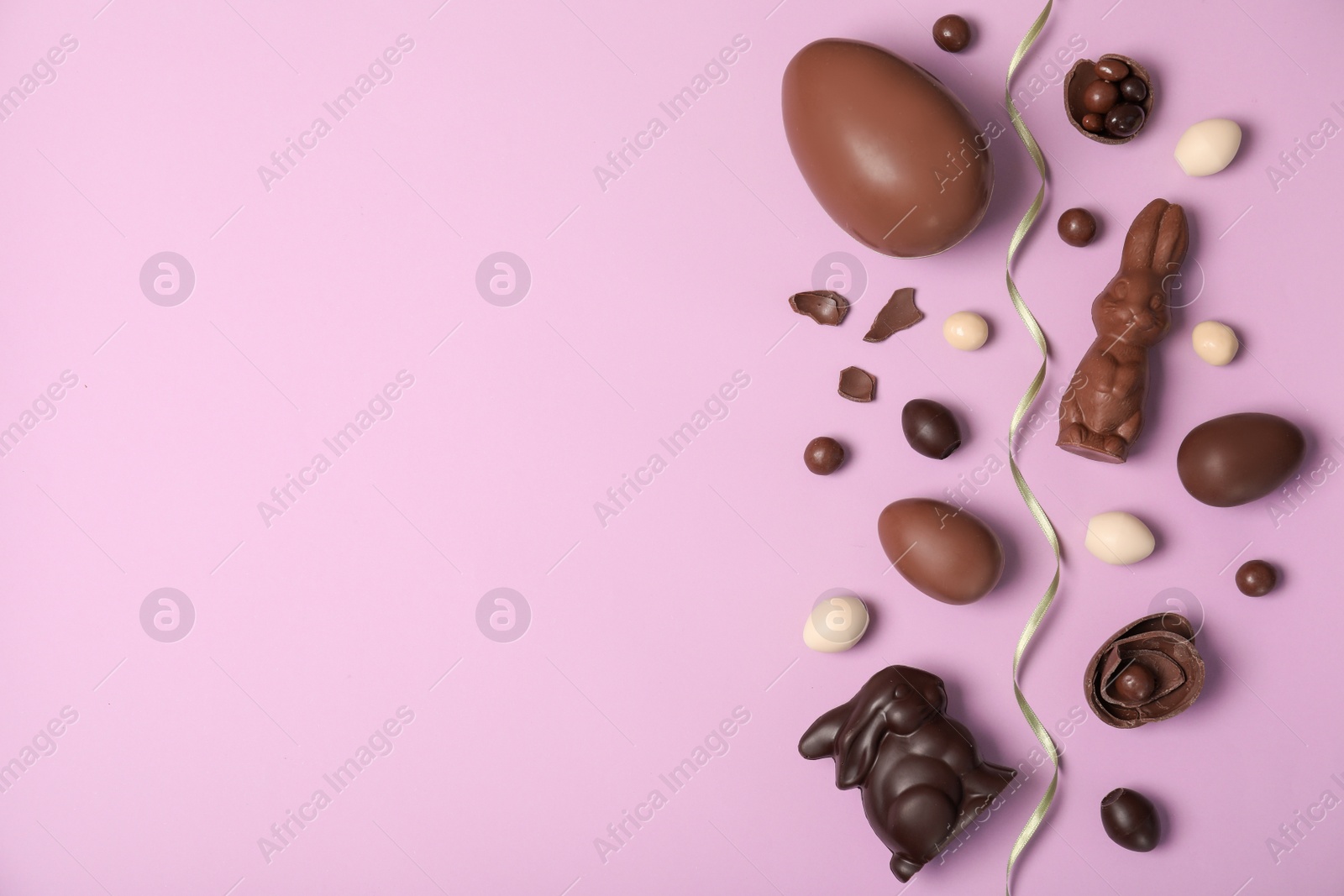 Photo of Flat lay composition with chocolate Easter eggs and space for text on color background