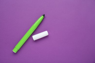 Light green marker on purple background, flat lay. Space for text