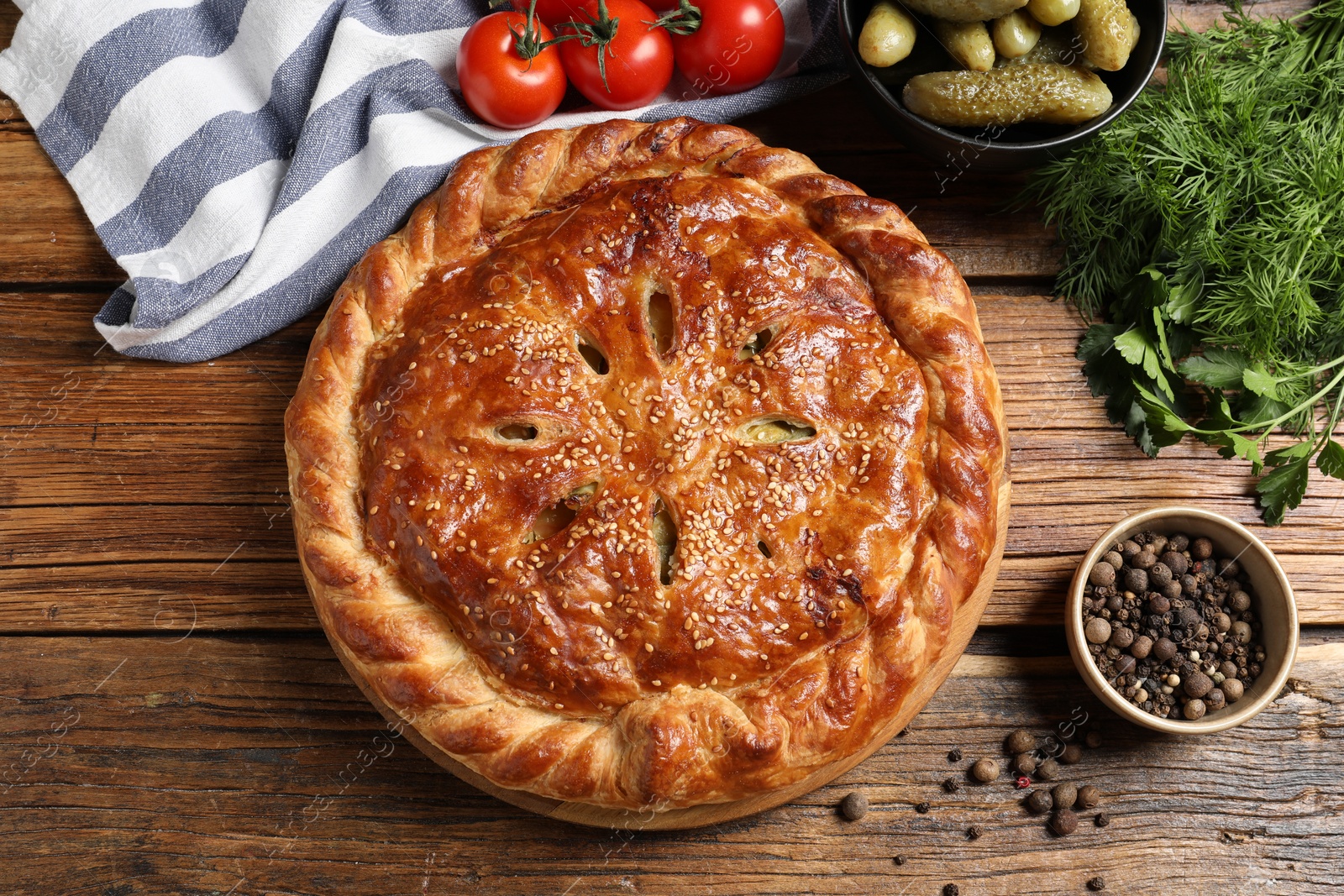 Photo of Tasty homemade pie and ingredients on wooden table, flat lay