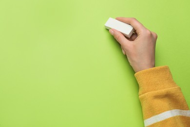 Photo of Woman erasing something on green background, closeup. Space for text