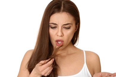 Photo of Emotional woman with damaged hair on white background. Split ends