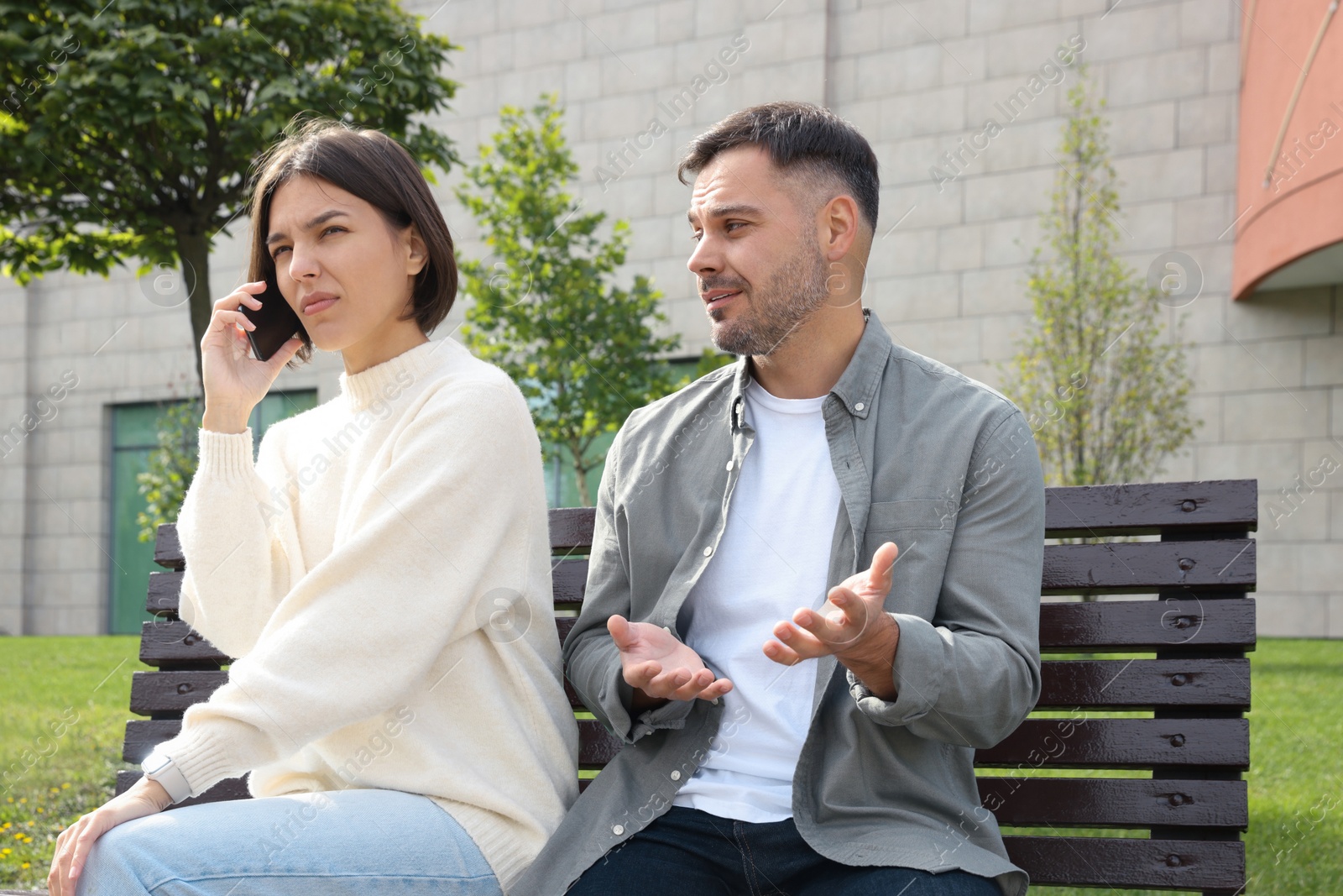 Photo of Woman ignoring her boyfriend and talking on phone. Relationship problems