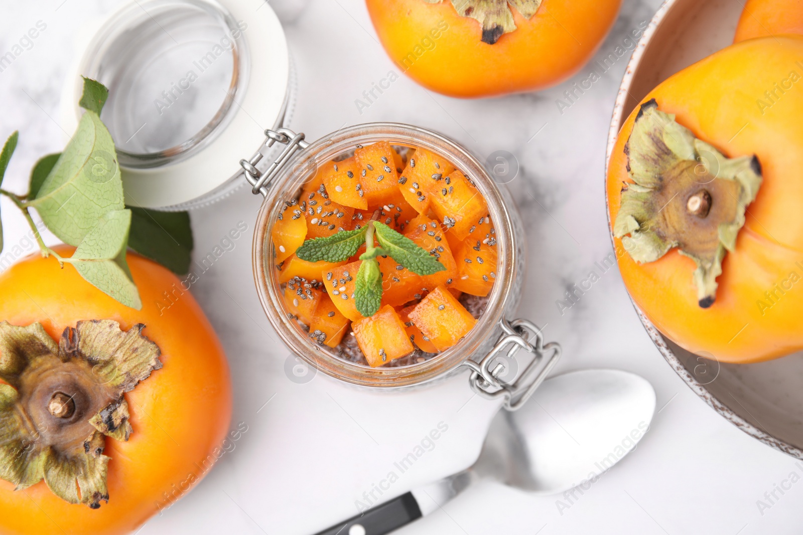 Photo of Delicious dessert with persimmon and chia seeds on table, flat lay