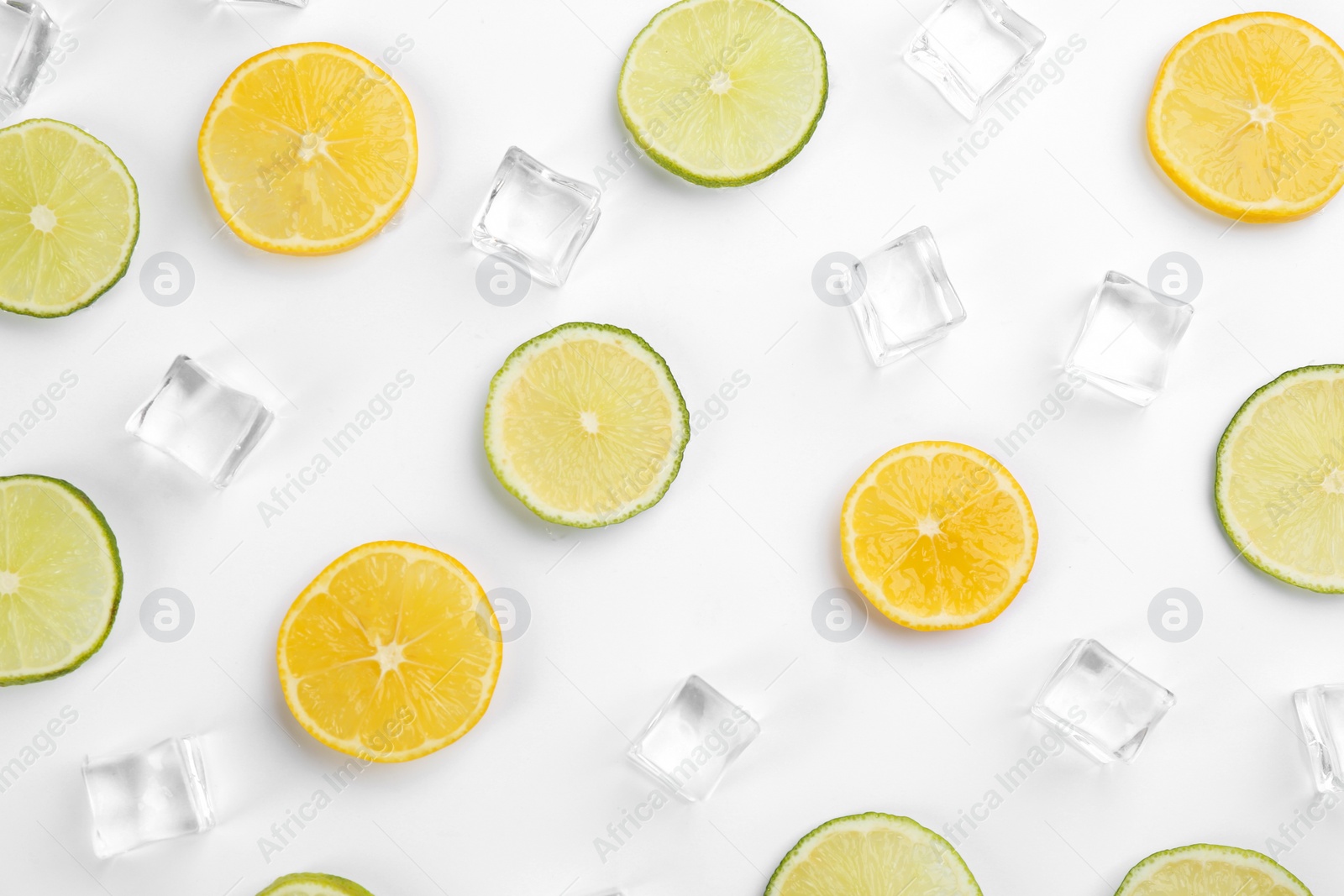 Photo of Lemonade layout with ice cubes, lime and orange slices on white background, top view