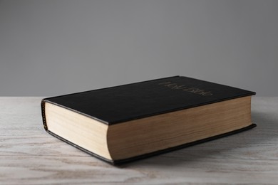 Photo of Bible with dark cover on wooden table. Christian religious book