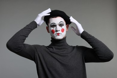 Photo of Mime artist in beret posing on grey background
