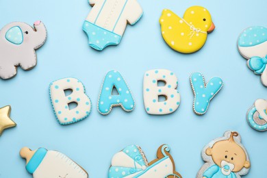 Photo of Word BABY and tasty cookies on light blue background, flat lay