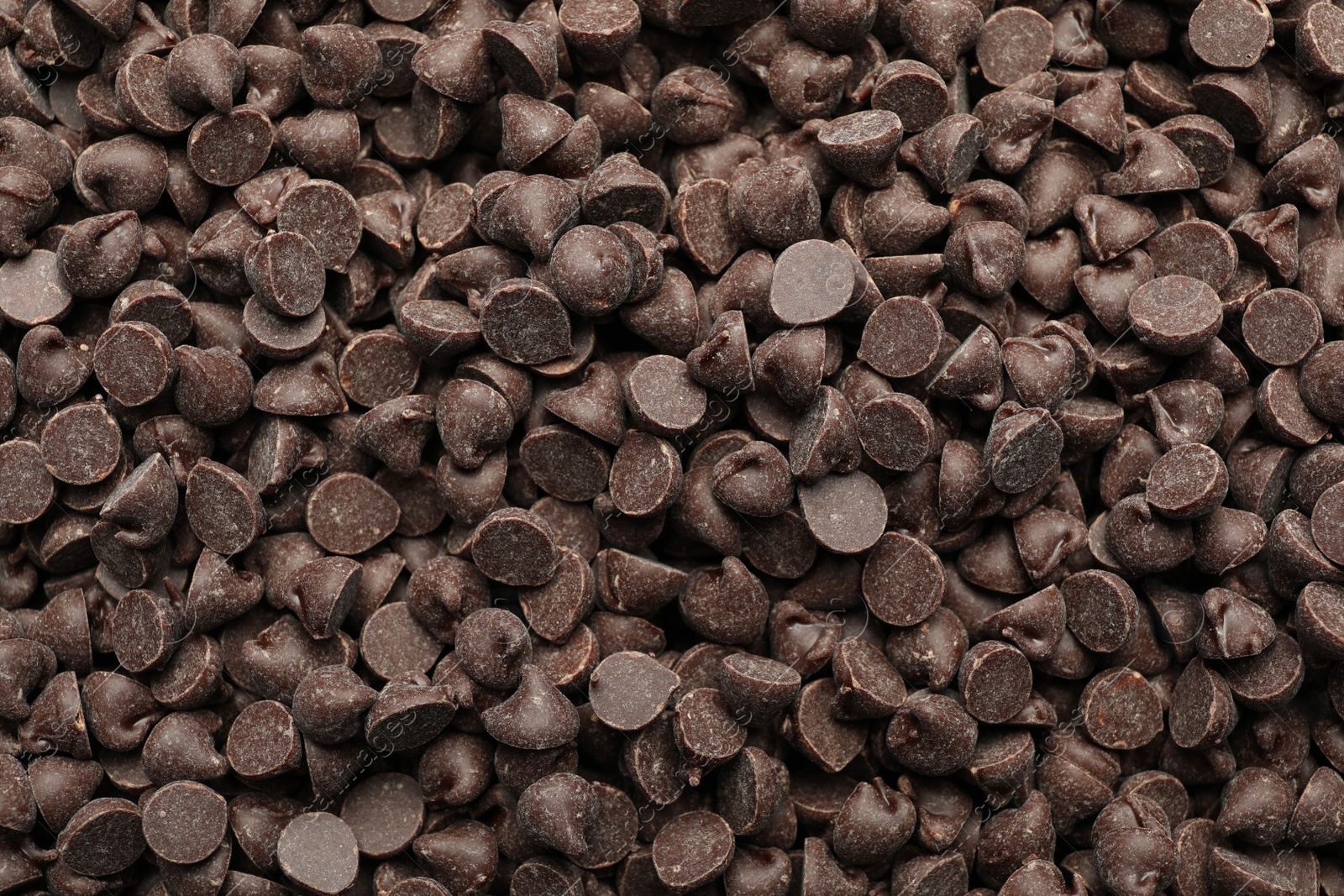 Photo of Delicious chocolate chips as background, top view