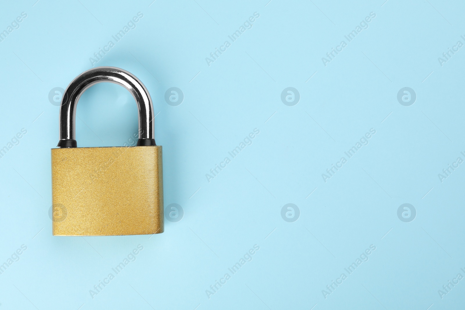 Photo of Modern padlock on light blue background, top view. Space for text