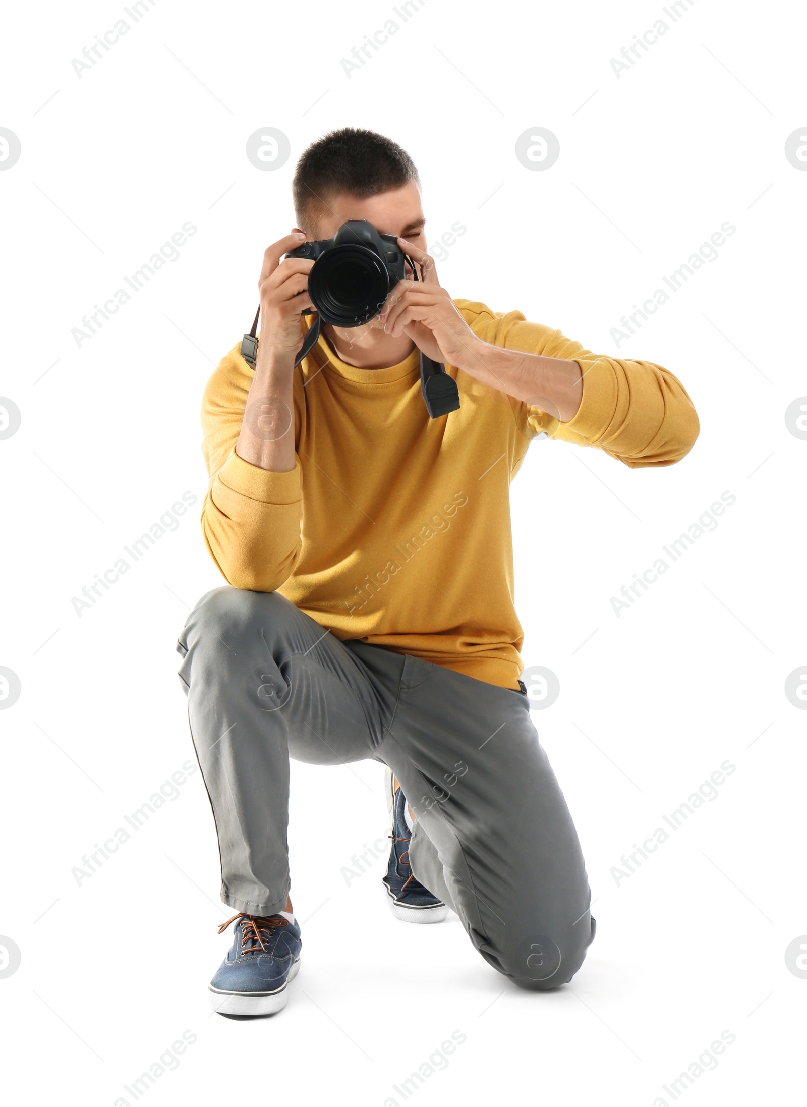 Photo of Young professional photographer taking picture on white background