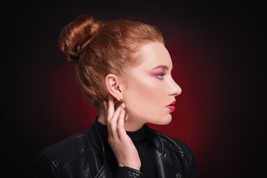 Portrait of beautiful young woman with makeup posing on color background