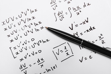 Photo of Sheet of paper with mathematical formulas and pen, top view