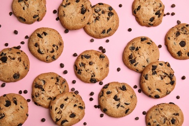 Delicious chocolate chip cookies on color background, flat lay