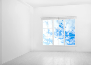 Image of Beautiful view on blue sky with clouds through window in room