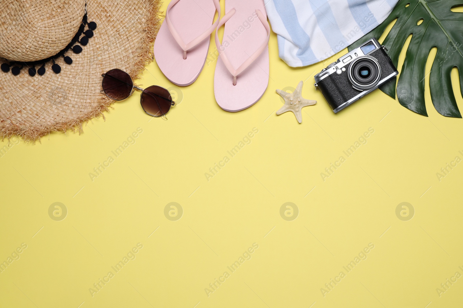 Photo of Flat lay composition with beach objects on yellow background. Space for text