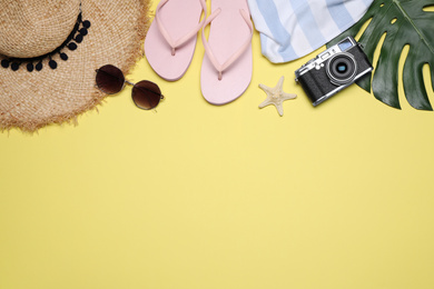 Flat lay composition with beach objects on yellow background. Space for text