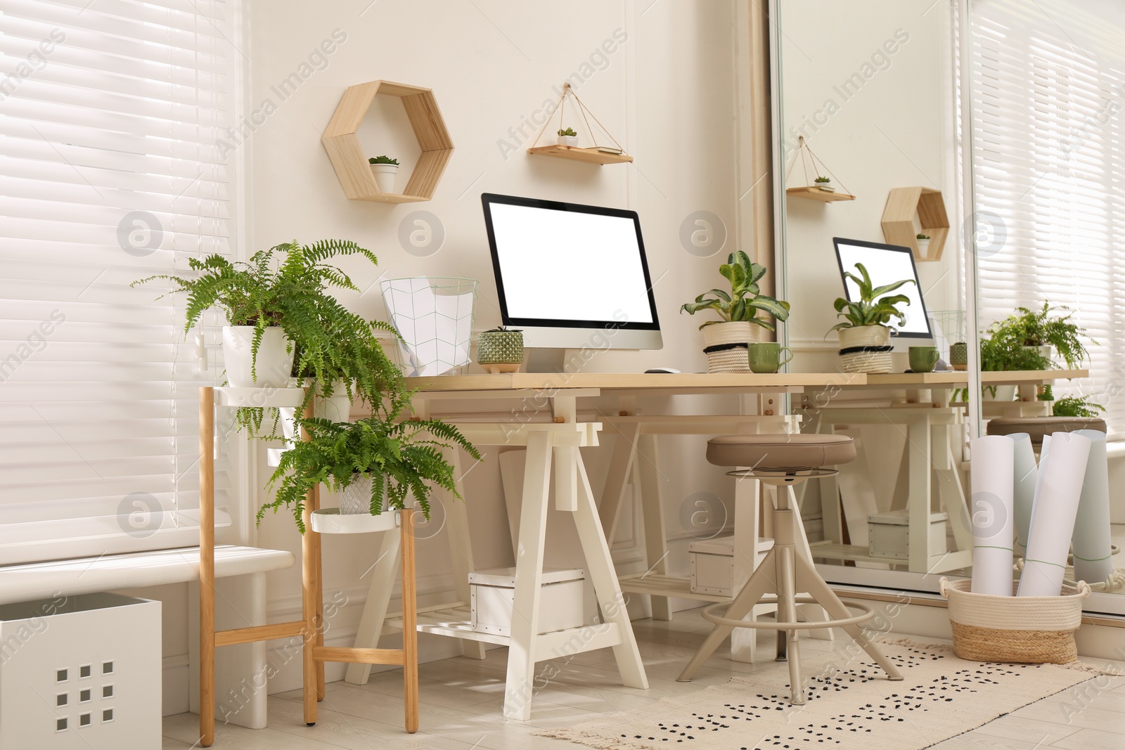 Photo of Comfortable workplace with modern computer and houseplants in room. Interior design