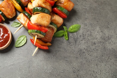 Delicious chicken shish kebabs with vegetables on grey table, closeup