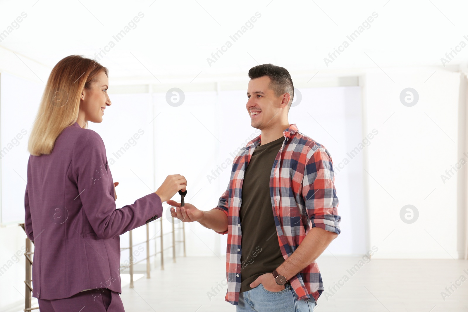Photo of Real estate agent giving apartment keys to client indoors
