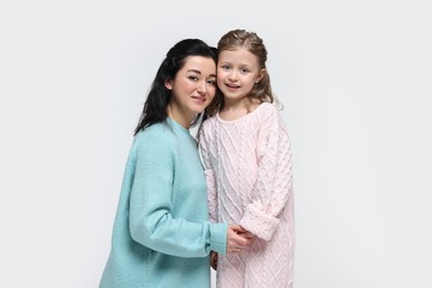 Beautiful mother with little daughter on white background