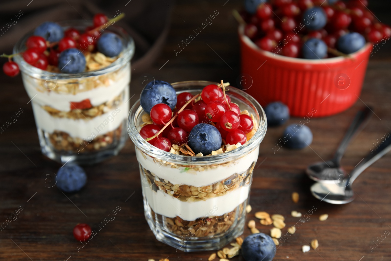 Photo of Delicious yogurt parfait with fresh berries on wooden table, closeup