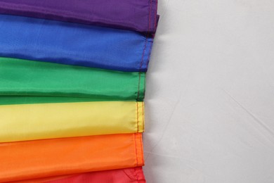 Photo of Rainbow LGBT flag on white background, top view. Space for text