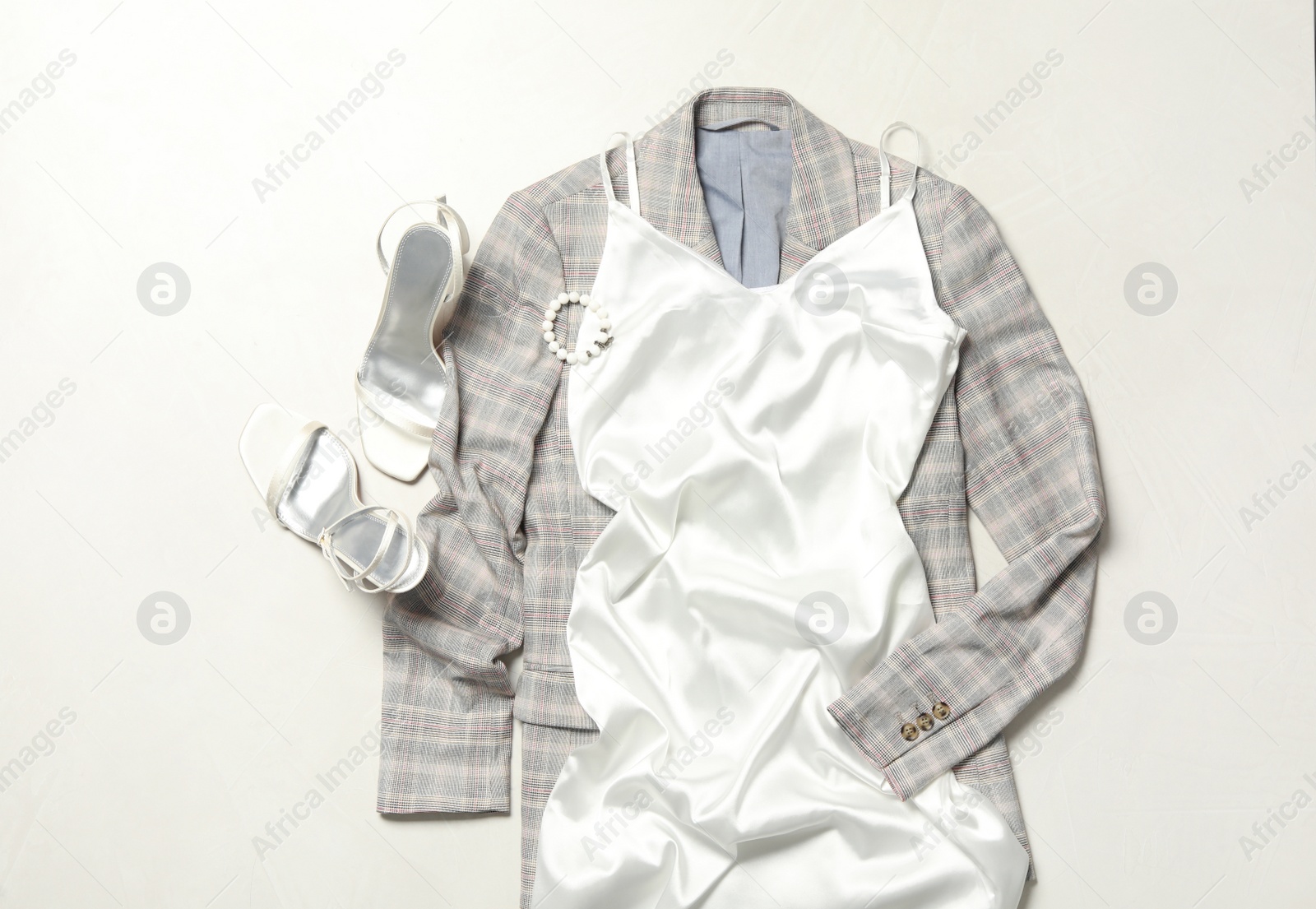Photo of Flat lay composition with stylish white dress on light background