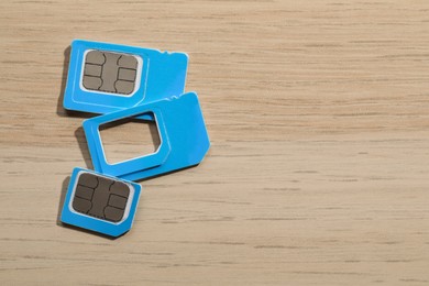 Photo of SIM cards on wooden background, flat lay. Space for text