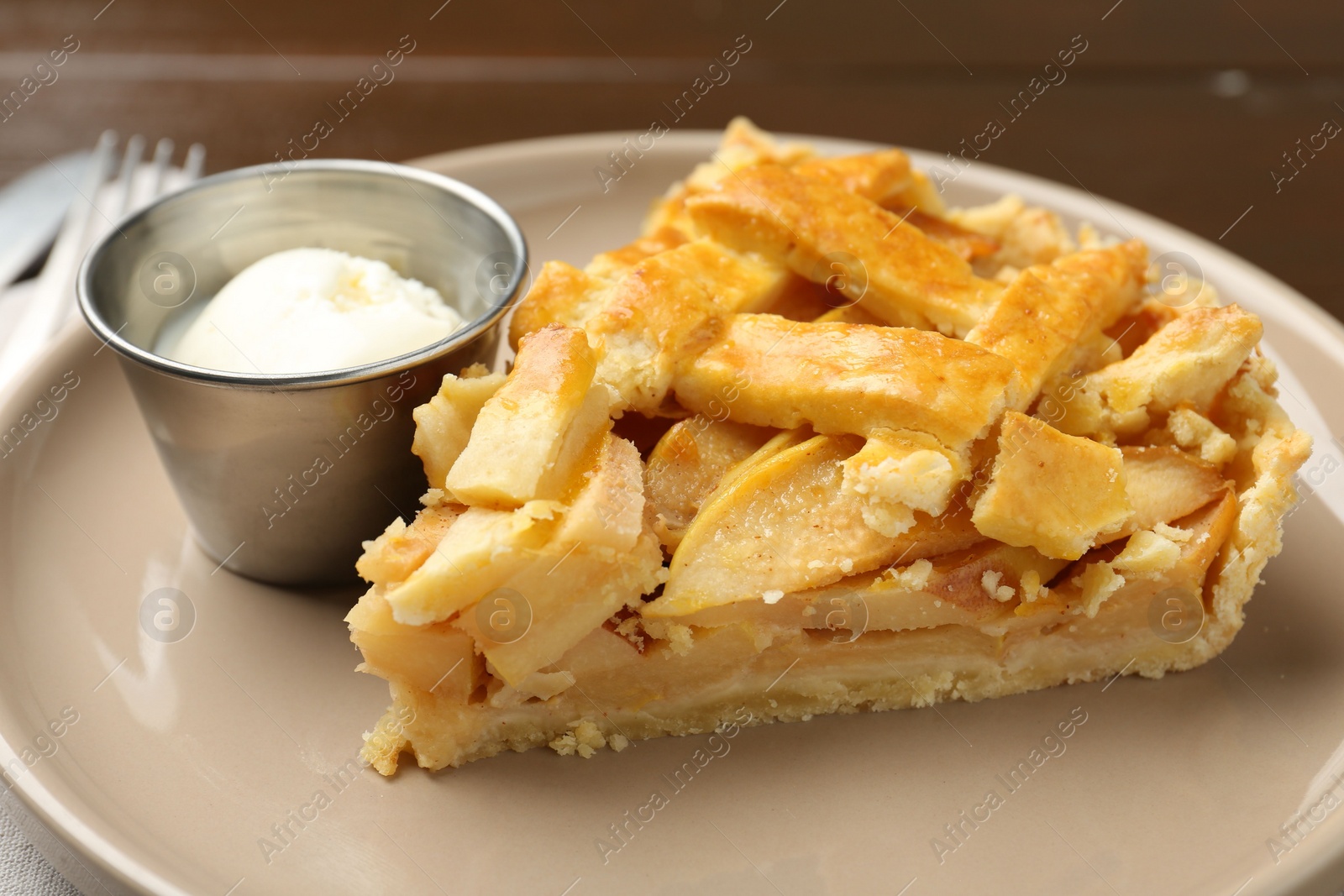 Photo of Piece of tasty homemade quince pie with ice cream on table, closeup