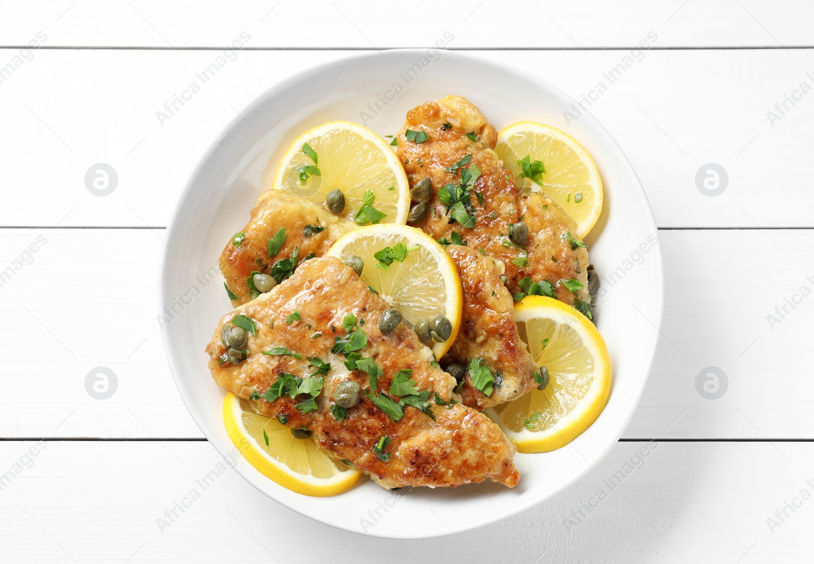 Photo of Delicious chicken piccata on white wooden table, top view