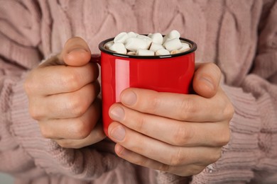 Woman holding cup of delicious hot chocolate with marshmallows, closeup