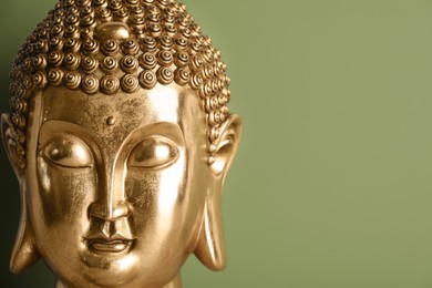 Beautiful golden Buddha sculpture on green background, closeup. Space for text