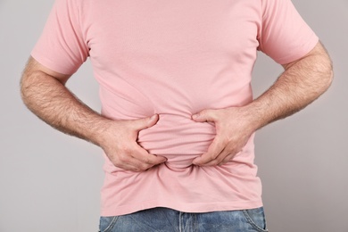 Photo of Overweight man with large belly on color background, closeup